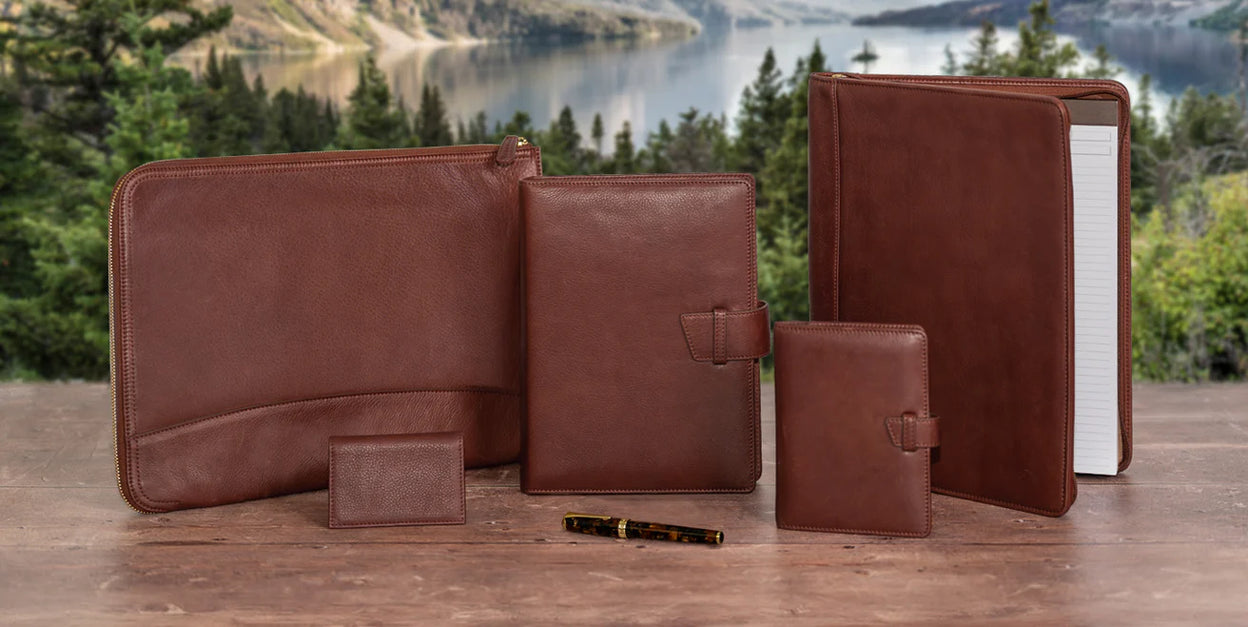 A neatly packed weekender bag with a discbound notebook, zip folio, index cards, a compact planner, and a rollerball pen arranged on a wool throw.