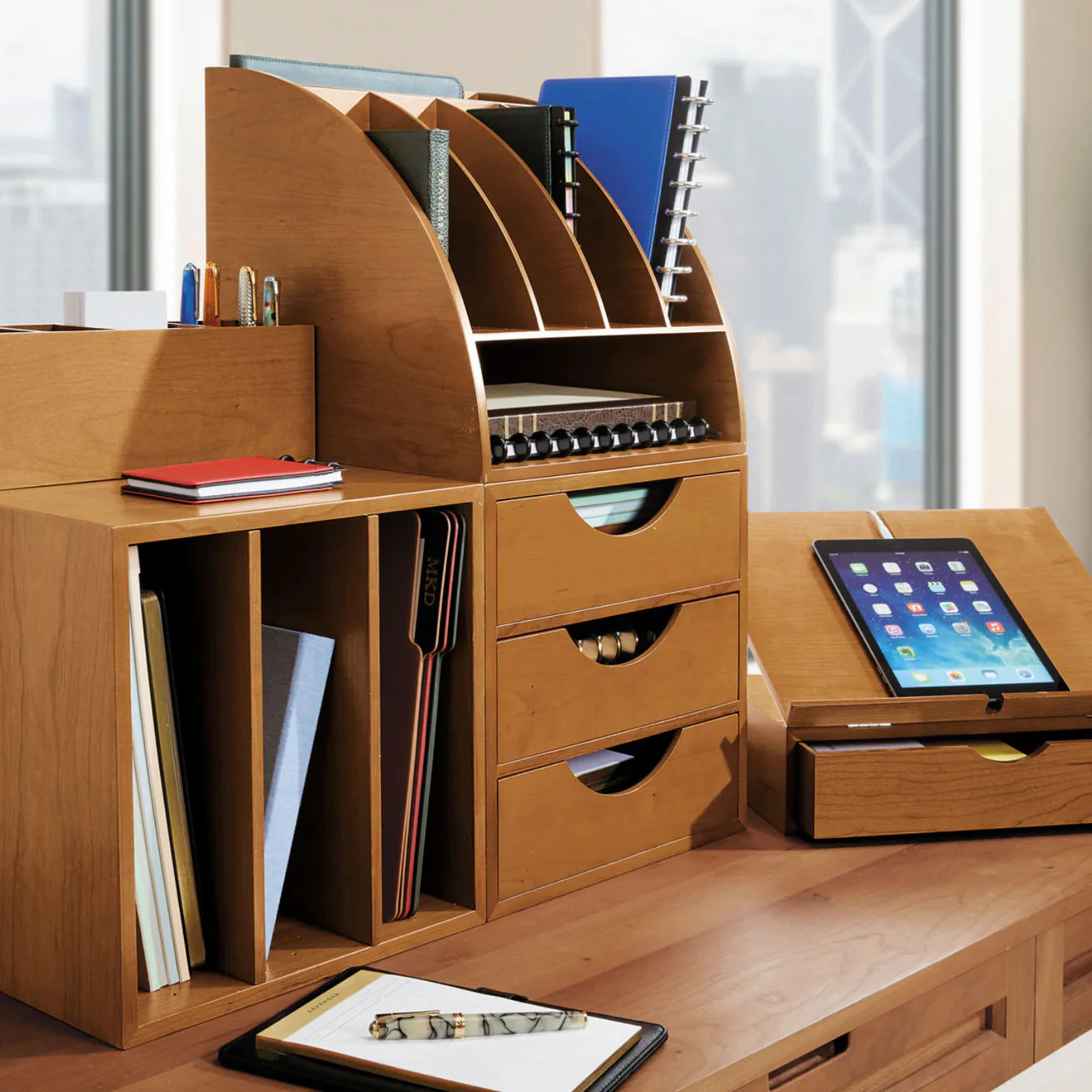 A professional relaxing in a window seat using the Levenger Lap Desk with a hardcover book and a pen nearby, conveying comfort and focus.