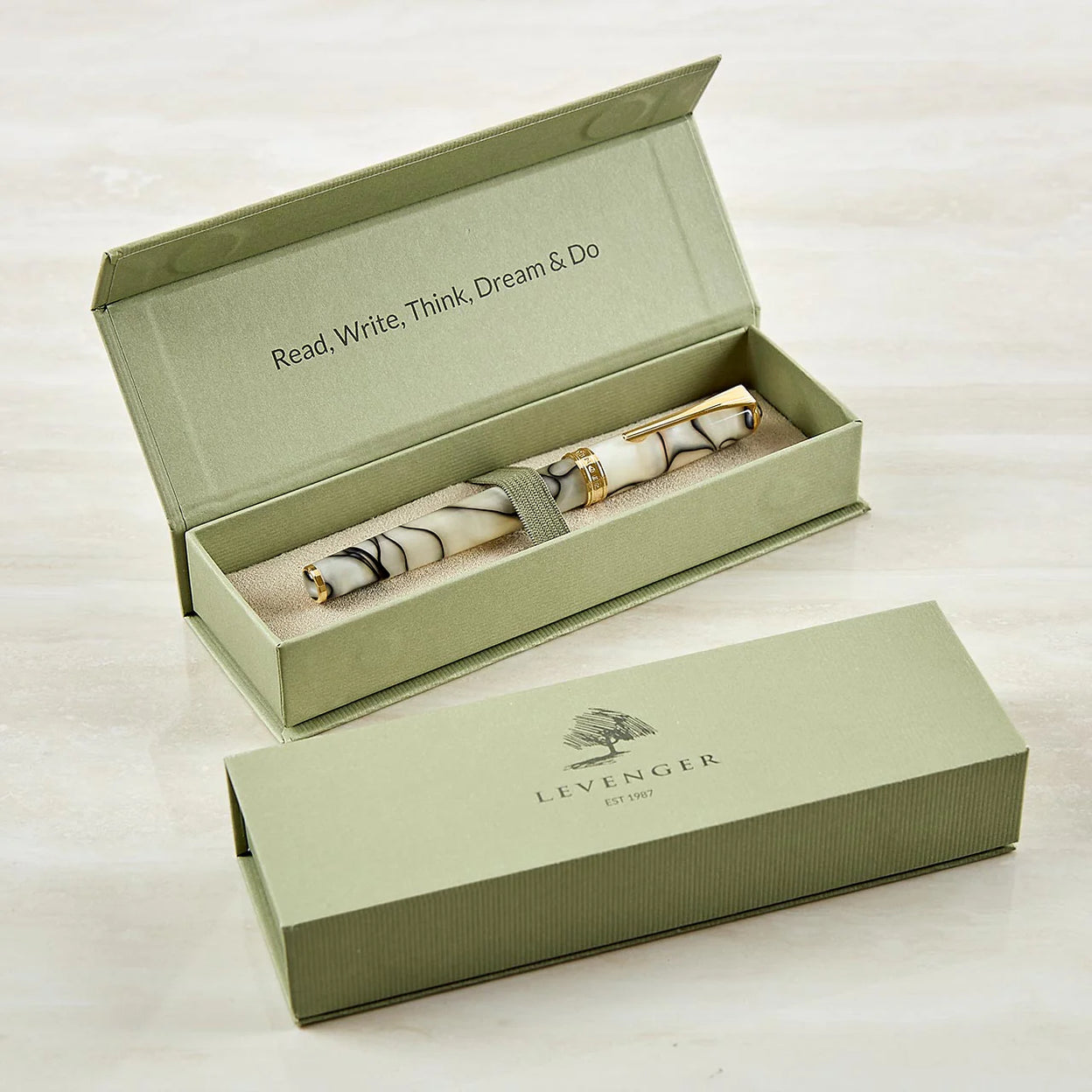 A selection of Levenger leather folios and Circa covers arranged with a logo proof, gift boxes, and personalized cards—an organized view of a corporate gifting order.