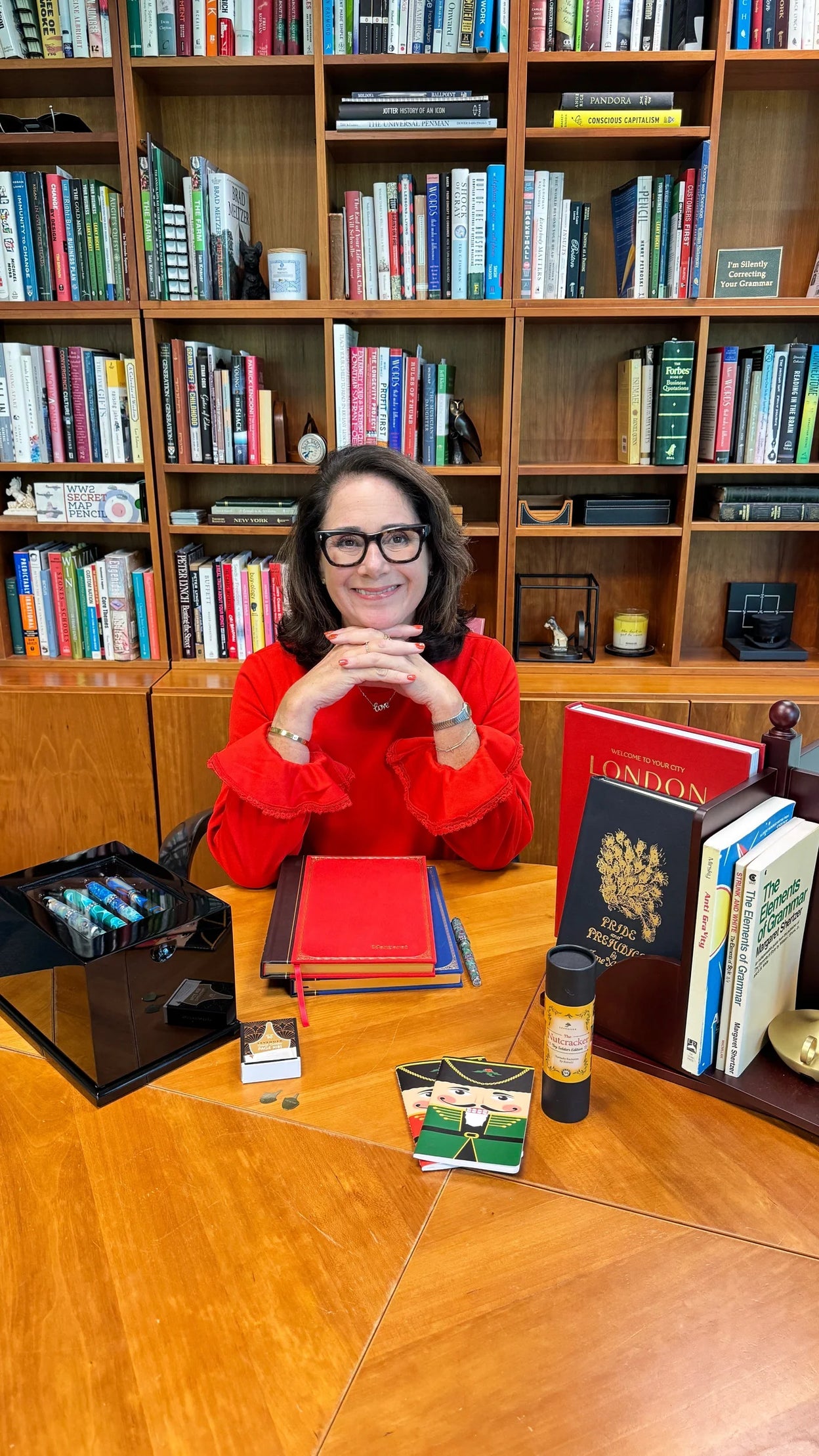 A reader relaxing in a chair with a wood lap desk and an angled book stand positioned at eye level beside a warm book light.