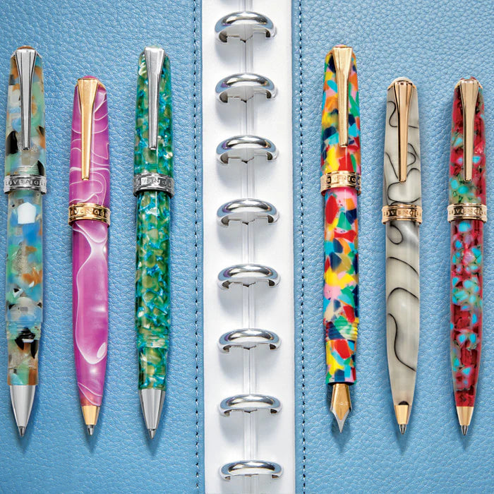 A flat-lay comparing a Levenger Circa disc-bound notebook, a three-ring binder, and a hardcover bound journal with pens and index tabs.
