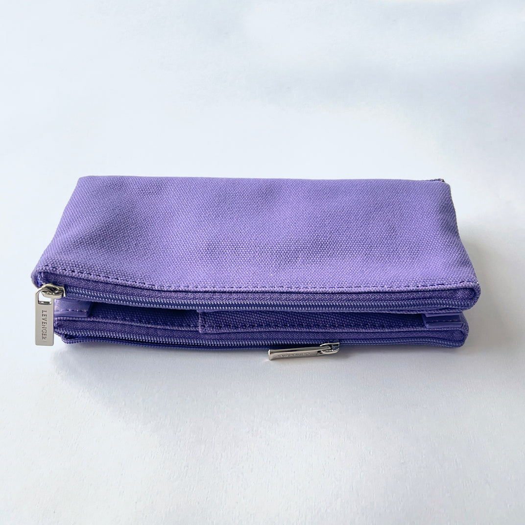 Purple canvas double zip pen case resting on a white surface